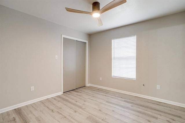 unfurnished bedroom featuring light hardwood / wood-style floors, a closet, and ceiling fan