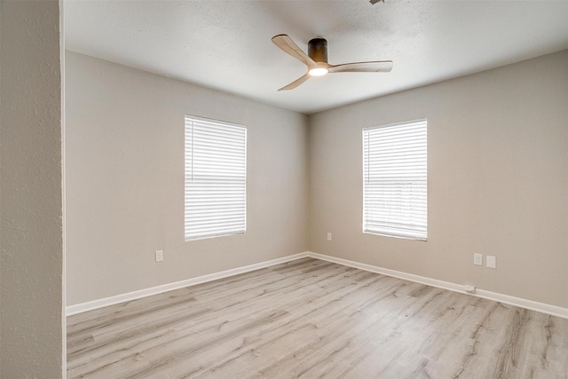 spare room featuring a textured ceiling, ceiling fan, and light wood-type flooring