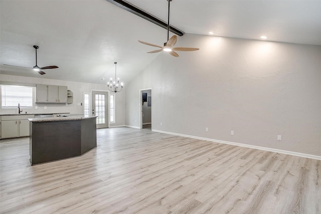 kitchen featuring beamed ceiling, sink, a wealth of natural light, and light hardwood / wood-style flooring