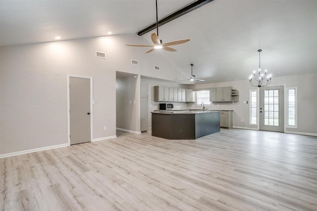 kitchen featuring beam ceiling, gray cabinets, light hardwood / wood-style floors, and a center island