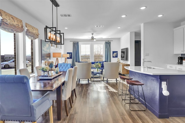 dining room featuring sink, hardwood / wood-style floors, and ceiling fan