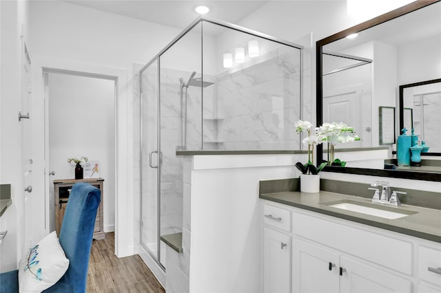 bathroom featuring hardwood / wood-style flooring, vanity, and a shower with shower door