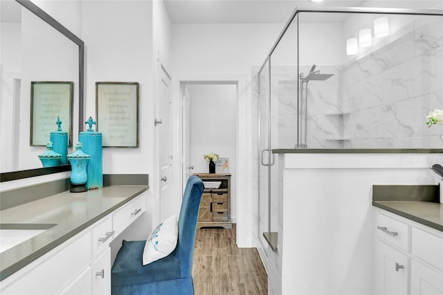 bathroom with walk in shower, vanity, and wood-type flooring