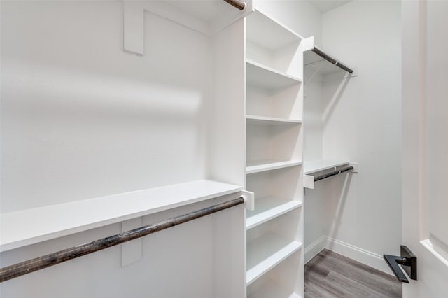 walk in closet with light hardwood / wood-style floors