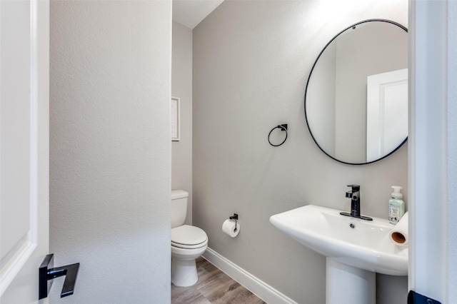 bathroom with hardwood / wood-style flooring, sink, and toilet