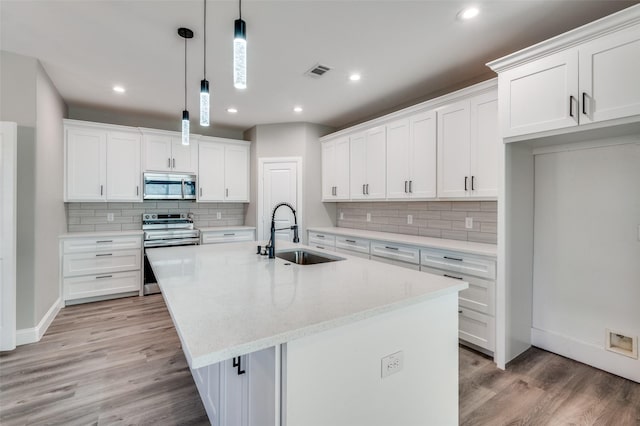 kitchen with a kitchen island with sink, sink, stainless steel appliances, and white cabinets