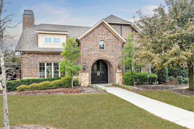 view of front of property with a front lawn and french doors