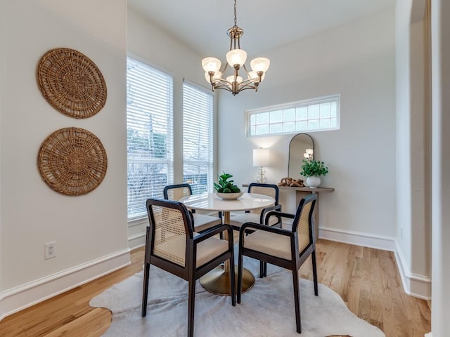 dining space with an inviting chandelier and light hardwood / wood-style floors