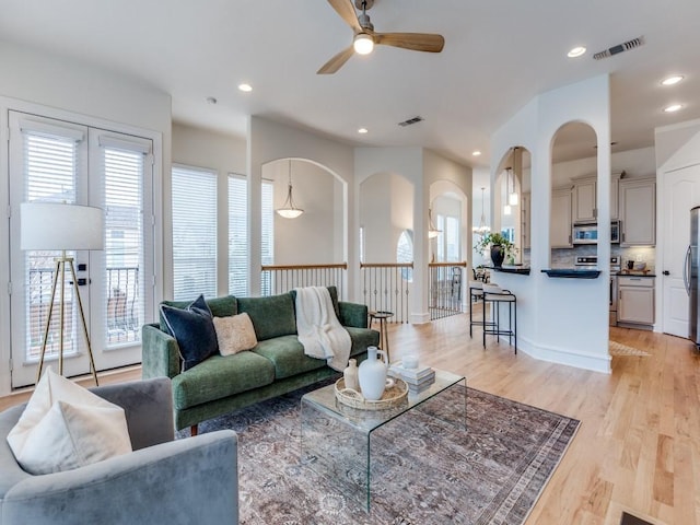 living room with light hardwood / wood-style flooring and ceiling fan