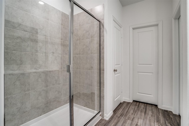 bathroom featuring an enclosed shower and wood-type flooring