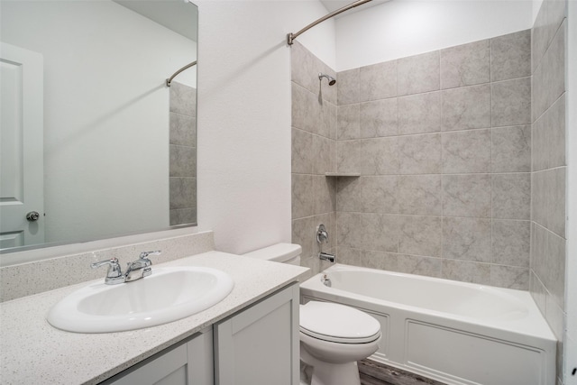 full bathroom with vanity, tiled shower / bath combo, and toilet