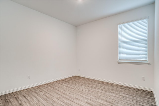 spare room featuring light hardwood / wood-style floors and a healthy amount of sunlight