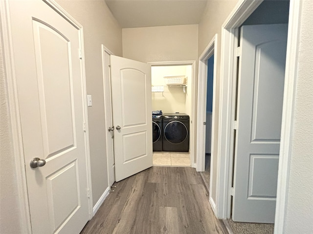 hallway with washer and clothes dryer and light hardwood / wood-style floors