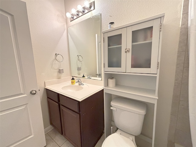 bathroom with tile patterned flooring, vanity, and toilet