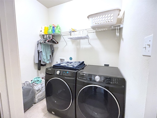 washroom with light tile patterned floors and washer and dryer