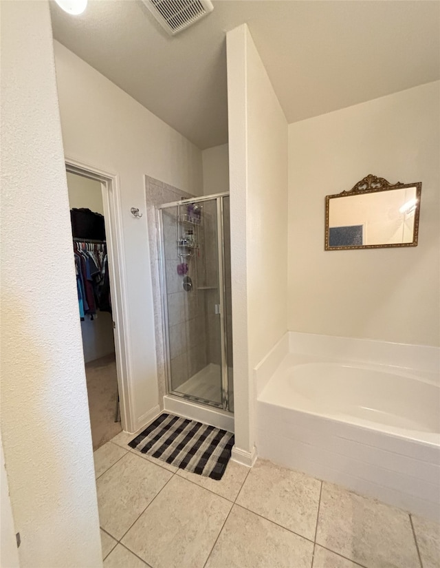 bathroom with tile patterned floors and shower with separate bathtub