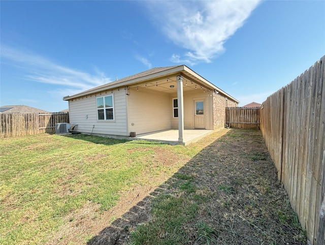 rear view of house featuring central AC, a yard, and a patio