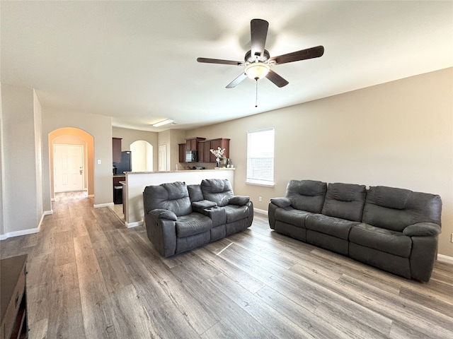 living room featuring wood-type flooring and ceiling fan