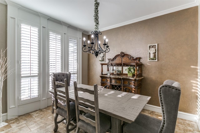 dining room with a notable chandelier, ornamental molding, and baseboards