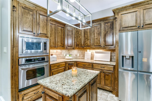 kitchen featuring light tile patterned floors, light stone countertops, stainless steel appliances, a center island, and tasteful backsplash