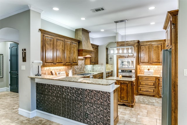 kitchen with arched walkways, a peninsula, premium range hood, appliances with stainless steel finishes, and ornamental molding