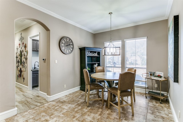 dining room with baseboards, arched walkways, and crown molding