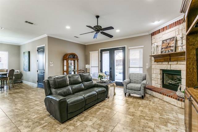 living area featuring baseboards, plenty of natural light, visible vents, and crown molding