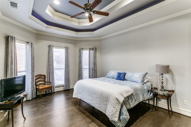 bedroom featuring a raised ceiling, visible vents, crown molding, and wood finished floors