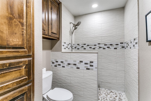 bathroom with toilet and tiled shower