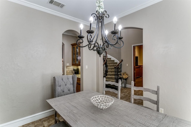 dining room featuring baseboards, visible vents, arched walkways, stairway, and crown molding