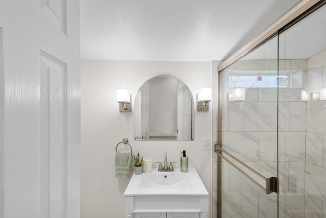 bathroom with a shower with door and vanity