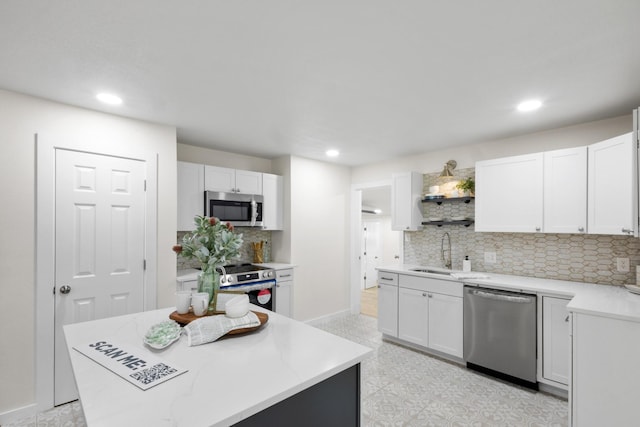 kitchen with white cabinetry, sink, a kitchen island, and appliances with stainless steel finishes