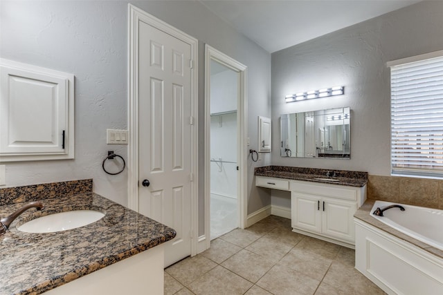 bathroom featuring vanity, tile patterned flooring, and a tub