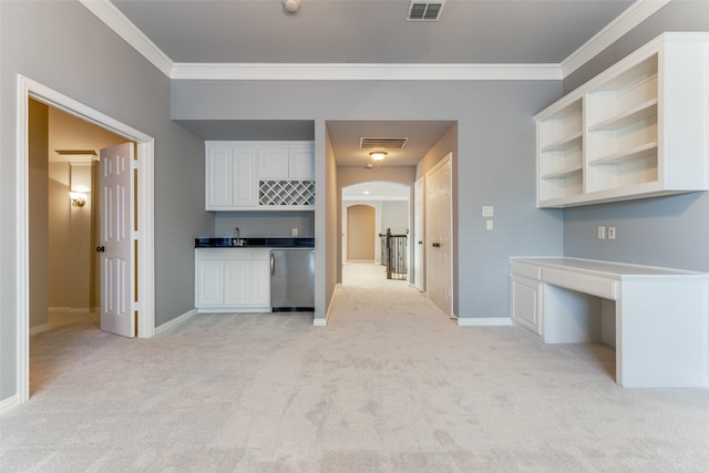 kitchen featuring white cabinetry, crown molding, light carpet, and stainless steel dishwasher