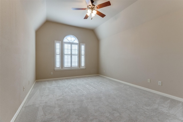 spare room featuring lofted ceiling, light carpet, and ceiling fan