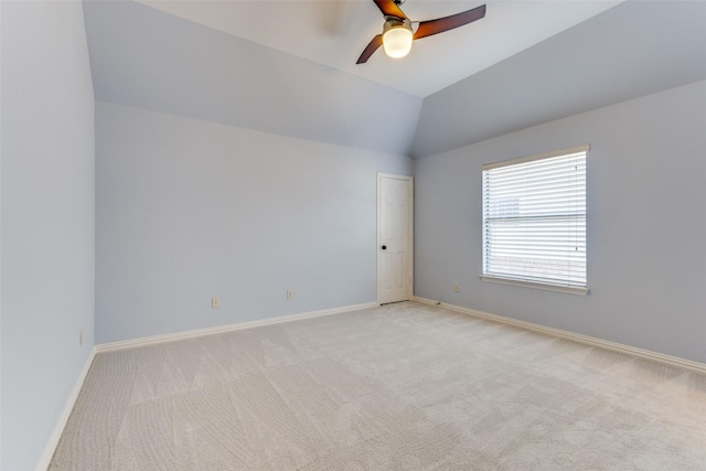 unfurnished room with ceiling fan, light colored carpet, and vaulted ceiling