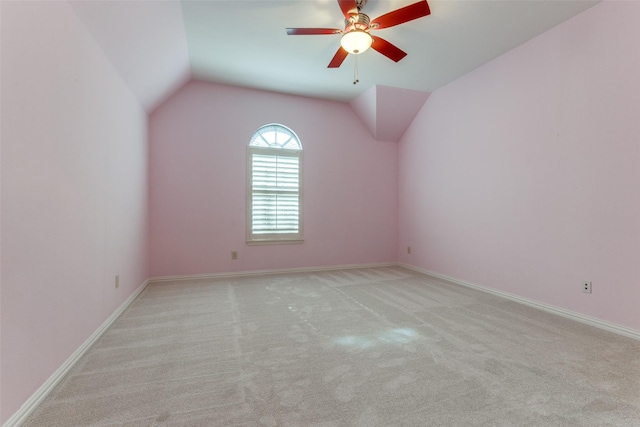 carpeted spare room with vaulted ceiling and ceiling fan