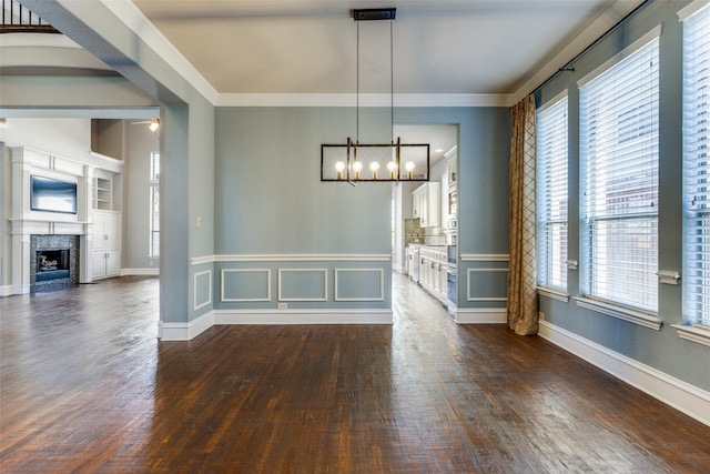 unfurnished dining area with crown molding, dark hardwood / wood-style floors, and a premium fireplace