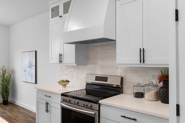 kitchen with premium range hood, tasteful backsplash, white cabinets, dark wood-type flooring, and stainless steel electric range