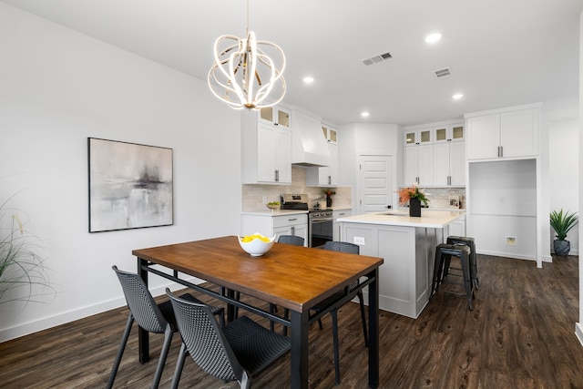 dining space with an inviting chandelier and dark hardwood / wood-style flooring