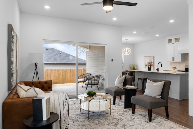 living room with hardwood / wood-style flooring, sink, and ceiling fan