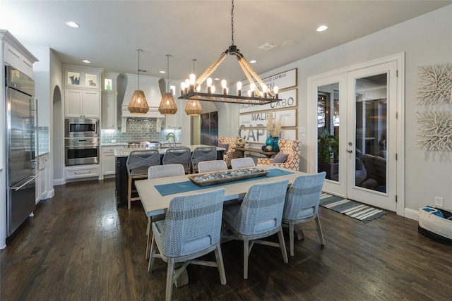 dining space with dark wood-type flooring, sink, and french doors