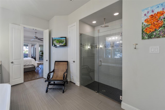 bathroom featuring ceiling fan and a shower with shower door