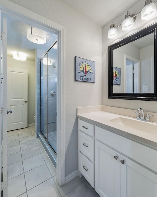 bathroom with tile patterned flooring, vanity, a shower with door, and toilet