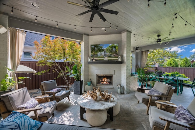 view of patio with ceiling fan and an outdoor living space with a fireplace