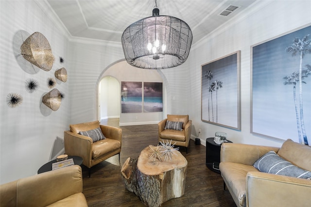 living room with an inviting chandelier, crown molding, and dark hardwood / wood-style floors