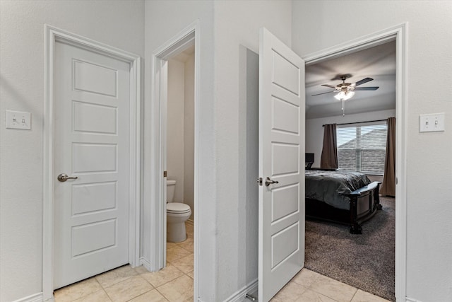 bathroom featuring ceiling fan, tile patterned floors, and toilet