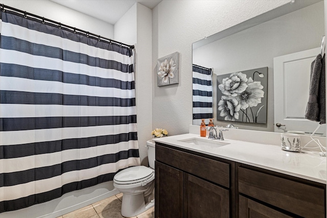 bathroom with tile patterned flooring, vanity, and toilet