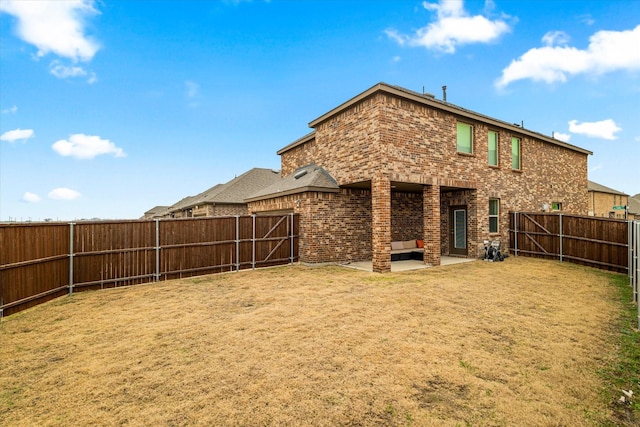 back of house with a lawn and a patio area