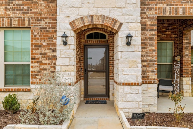 entrance to property with stone siding and brick siding